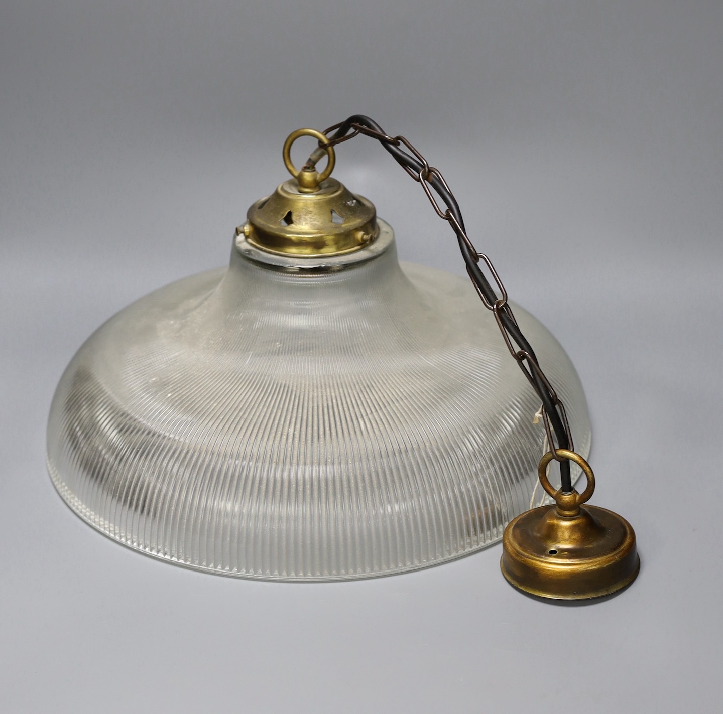 A clear ribbed glass shaded and brass pendant light, shade 37.5 cms diameter.